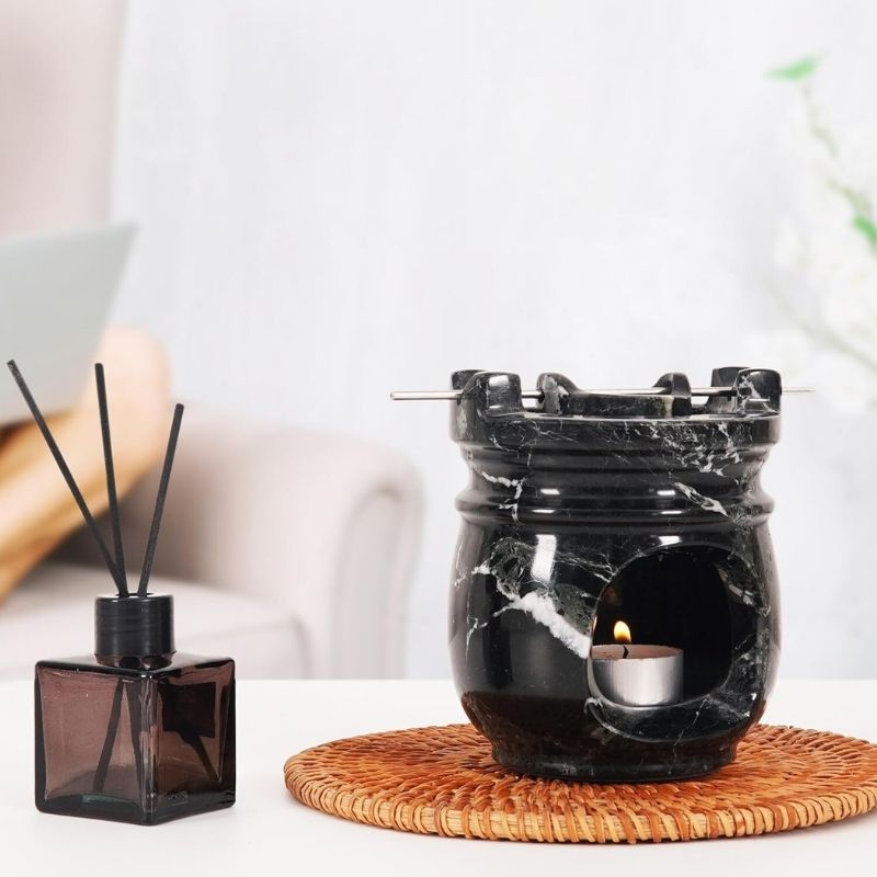 Black marble oil burner used as a decorative centerpiece on a living room table