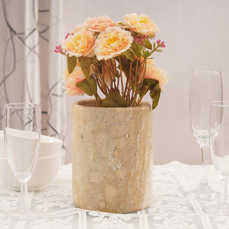 Flower bouquet in travertine vase used as table centerpiece decor