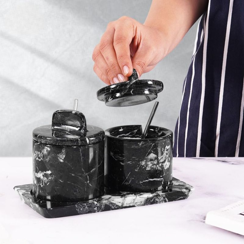 Elegant marble salt and sugar containers in black displayed on kitchen countertop