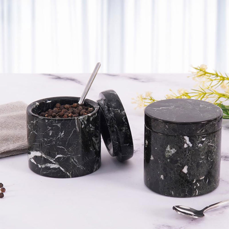 Salt container with lid on and spoon resting inside
