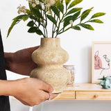 Person holding a 6 inches natural travertine marble flower vase filled with artificial flowers – perfect for living room, dining table, or home decor accent piece, highlighting earthy texture and outdoor-inspired ambiance.