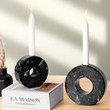 Black marble candle holders placed next to the book for cozy decor styling