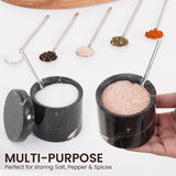 Black salt and pepper containers filled with various spices like chili, herbs, and rock salt
