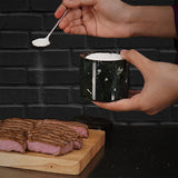 Black marble salt cellar used for seasoning on kitchen countertop