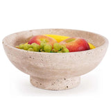 Marble fruit serving bowl placed on a wooden dining table with white background.