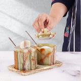 Elegant marble salt and sugar containers in green displayed on kitchen countertop