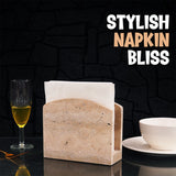 Natural stone napkin holder used as a kitchen counter accessory near utensils and spices