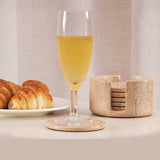 Glass of juice on a travertine marble coaster with a plate of croissants and a stone coaster holder in the background – perfect for dining table or breakfast setting.