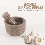 Hand using oceanic marble mortar and pestle to crush herbs and spices on kitchen counter