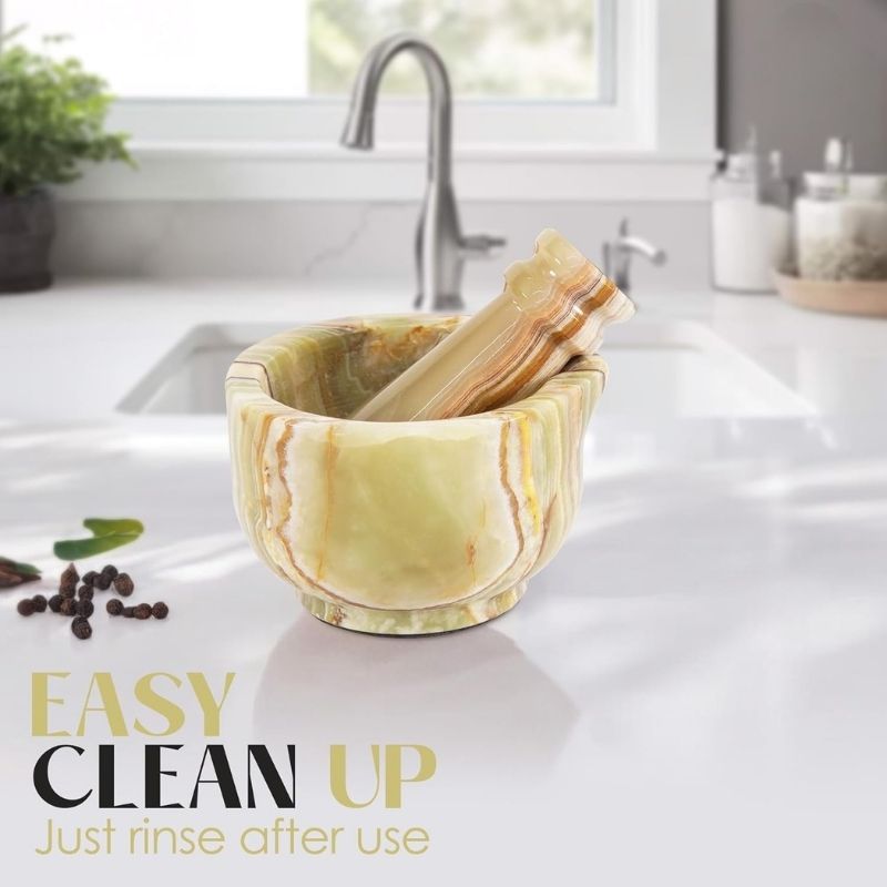 Easy-to-clean onyx green marble mortar and pestle set being rinsed under water or wiped with a cloth