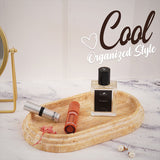 Oval travertine tray organizing perfumes and makeup in bathroom