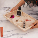 Rectangular travertine tray organizing perfumes and makeup in bathroom