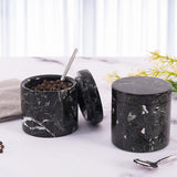 Salt container with lid on and spoon resting inside