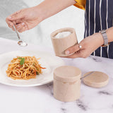 Hand sprinkling salt onto a freshly prepared meal using a verona marble salt cellar with spoon