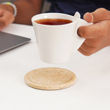 Travertine marble coasters used under coffee mugs and glasses on a table