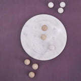 Overhead view of Travertine Marble Tic Tac Toe set with X and O pieces arranged in play, minimalistic flatlay on neutral tabletop – Speshstones