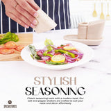 Hand sprinkling salt on fresh salad using marble salt and pepper shakers with tray in verona