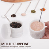 white salt and pepper containers filled with various spices like chili, herbs, and rock salt